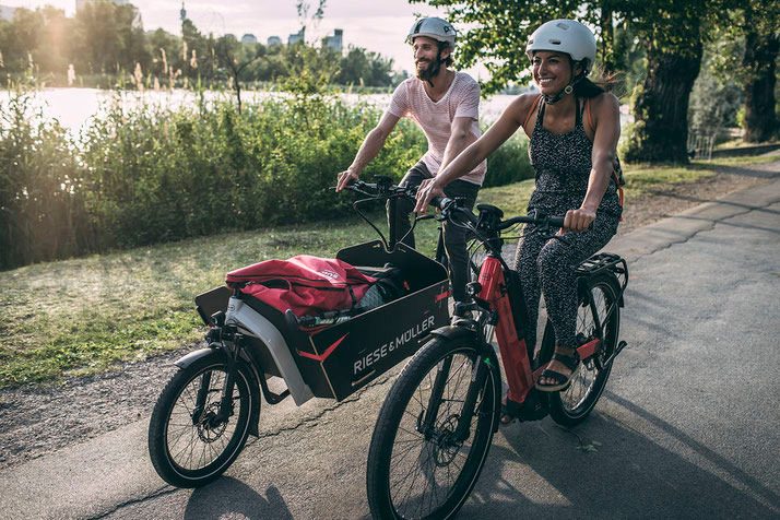 Paar auf E-Cargobikes von Riese & Müller